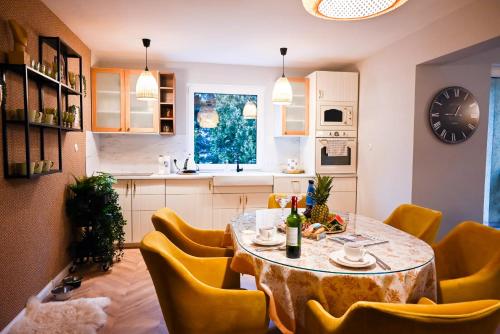 kuchnia i jadalnia ze stołem i żółtymi krzesłami w obiekcie Lubiński Resort w mieście Stężyca
