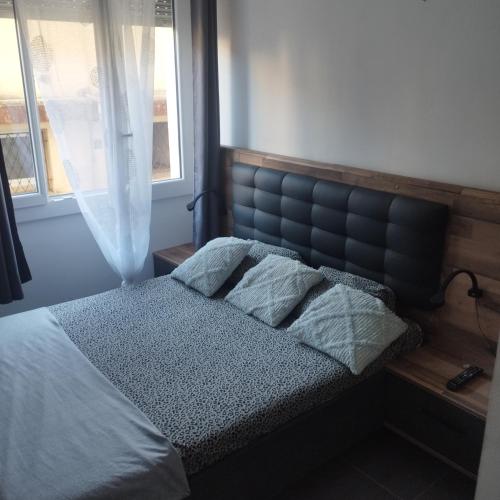 - une chambre avec un lit doté d'une tête de lit bleue et de deux oreillers dans l'établissement Jolie 2P au centre de golfe-juan à 2mn des plages, à Vallauris