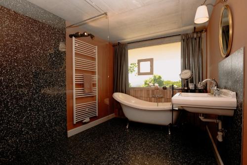 a bathroom with a tub and a sink and a window at Casa Kathinka in Fresing