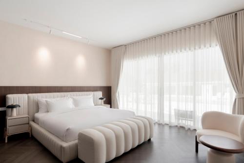 a bedroom with a white bed and a large window at Emmarin Villa Pattaya in Nong Prue