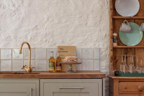 a kitchen counter with a sink and bottles of wine at The Granary in Yeovil