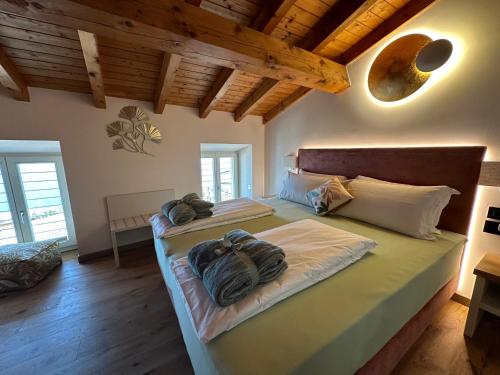 2 łóżka w sypialni z drewnianym sufitem i drewnianą podłogą w obiekcie Studios Al Castello dei Limoni w mieście Limone sul Garda