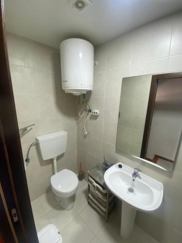 a bathroom with a toilet and a sink and a mirror at Rabacal Hotel Suite B&B with pool in Chanca