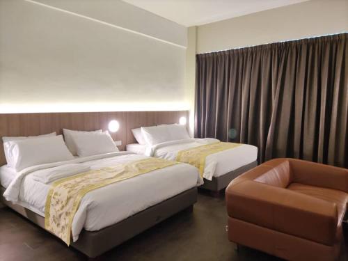 テメルローにあるBIG TREE HOTELのベッド2台と椅子があるホテルの部屋