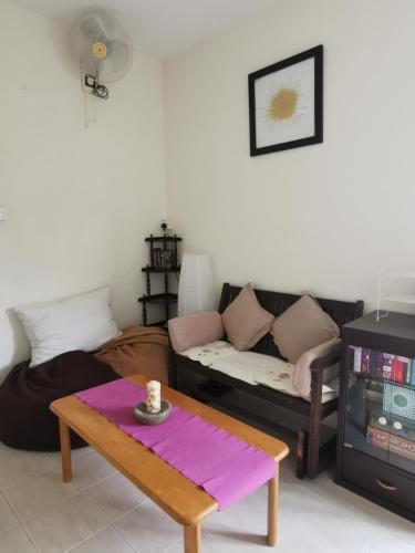 a living room with a couch and a table at Kampung In The City in Seri Kembangan