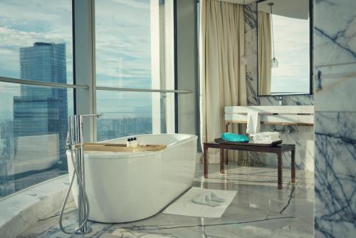 a bathroom with a bath tub and a table at Na Lotus Hotel, a Luxury Collection Hotel, Nanning in Nanning