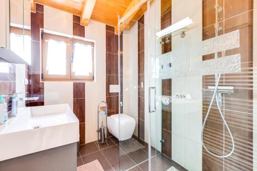 een badkamer met een douche, een wastafel en een toilet bij VB Jelčić Krk in Krk