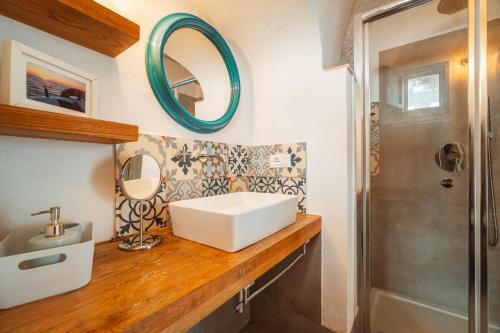 W łazience znajduje się umywalka i lustro. w obiekcie Poseidonia-Housea Travel w mieście Polignano a Mare
