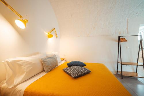 ポリニャーノ・ア・マーレにあるPoseidonia-Housea Travelのベッドルーム1室(オレンジ色の毛布付きのベッド1台付)