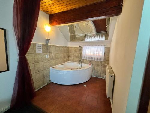 eine große Badewanne im Bad mit Fenster in der Unterkunft Bucharest West Motel in Domneşti