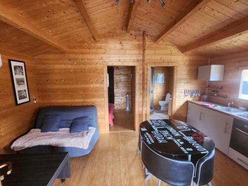 a log cabin with a bed and a table in it at Chalet 4 personnes à 5 mn des plages in Calcatoggio