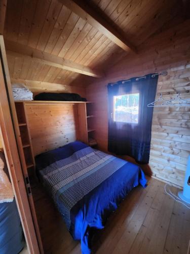 une chambre avec un lit dans une cabane en bois dans l'établissement Chalet 4 personnes à 5 mn des plages, à Calcatoggio