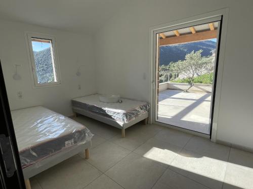 een kamer met een bed en een glazen schuifdeur bij Guetali du Village in Monacia-dʼAullène