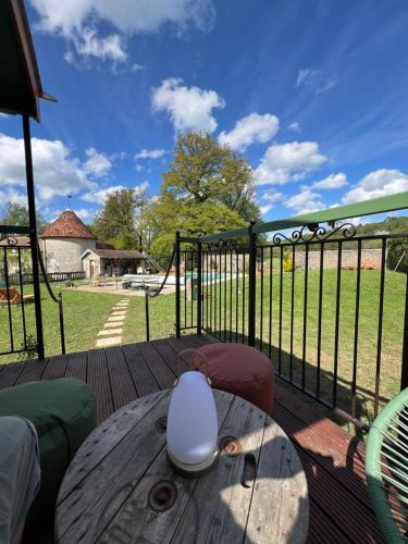 a wooden table on a deck with a fence at La Roulotte deluxe de Malpas in Quingey