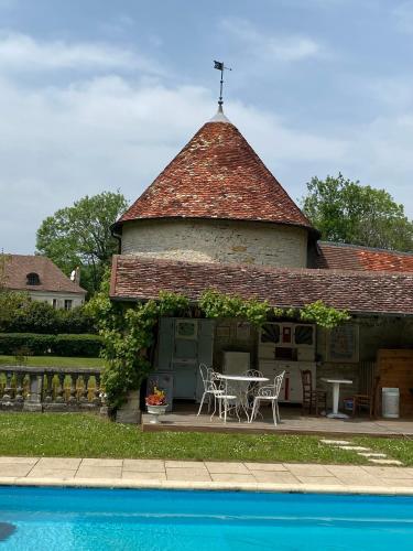a house with a table and chairs next to a pool at La Roulotte deluxe de Malpas in Quingey