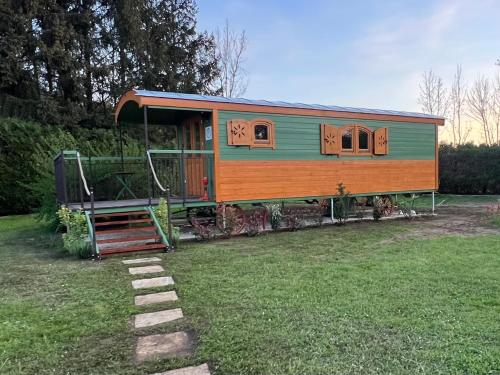 a small train car sitting in a yard at La Roulotte deluxe de Malpas in Quingey