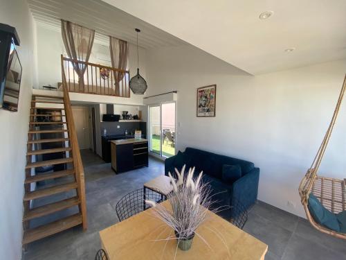 un salon avec un canapé bleu et une table dans l'établissement DUPLEX CALVI DIRECT PLAGE, à Calvi