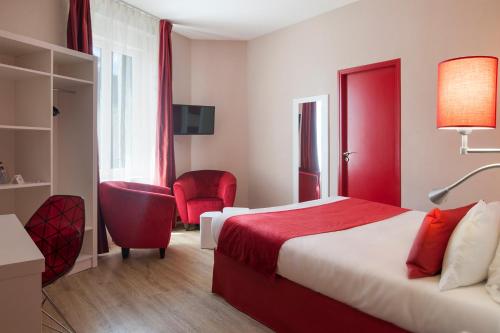 a hotel room with a red bed and a chair at The Originals Boutique, Hôtel de l'Univers, Montluçon in Montluçon