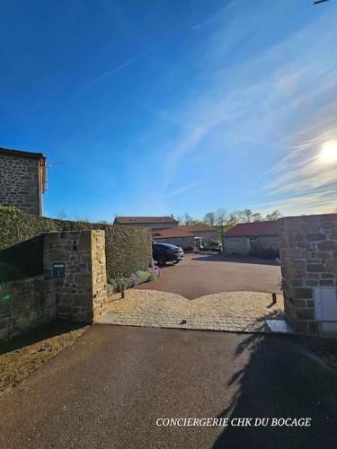 une allée avec une voiture garée dans un garage dans l'établissement La P'tite Crume joli gîte à 5 min du Puy du Fou, à La Verrie