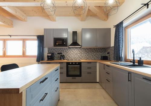 a kitchen with white cabinets and a counter top at Chata Pluskacka in Velké Karlovice