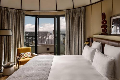 ein Schlafzimmer mit einem Bett und einem großen Fenster in der Unterkunft Hotel Norman Paris in Paris