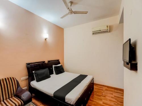 a bedroom with a bed and a tv and a couch at Super OYO Le Regent in Gurgaon