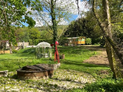 a garden with a bird bath in the grass at La Roulotte deluxe de Malpas in Quingey