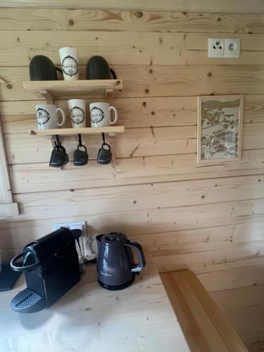 a room with a wooden wall with clocks and a tea kettle at La Roulotte deluxe de Malpas in Quingey