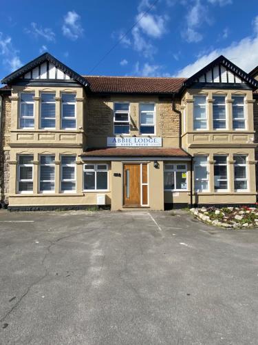 a building with a parking lot in front of it at Abbie Lodge Guest House in Weston-super-Mare