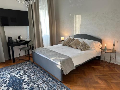 een slaapkamer met een bed, een tafel en een tapijt bij Garden View boutique apartments in Gorizia
