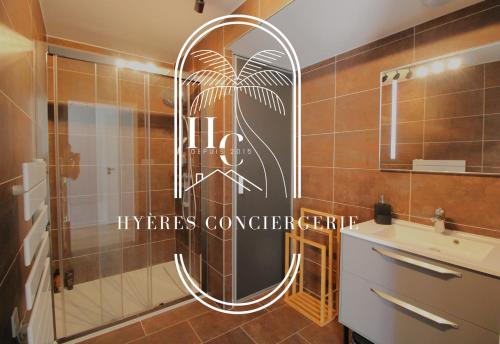 La salle de bains est pourvue d'une douche avec un miroir et un lavabo. dans l'établissement Les Terrasses du Niel Giens By HC, à Hyères