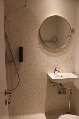 a bathroom with a sink and a mirror on the wall at Milling Hotel Mini 11 in Odense