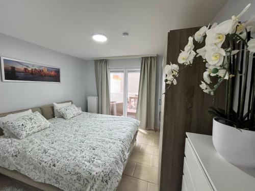 ein Schlafzimmer mit einem Bett und einer Vase aus Blumen in der Unterkunft 'Broker' - Amazing 2 bedroom apartment near the beach in Ostende