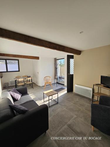 un salon avec un canapé et une table dans l'établissement La P'tite Crume joli gîte à 5 min du Puy du Fou, à La Verrie