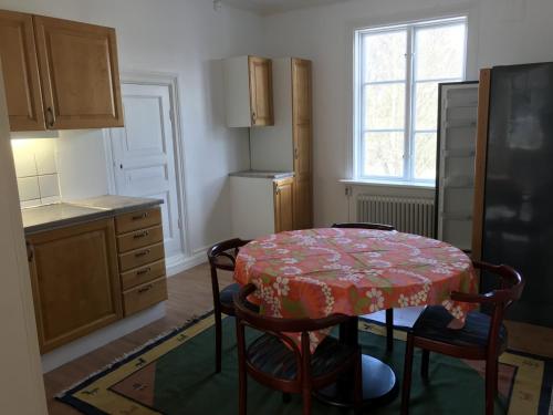 a kitchen with a table and some chairs and a refrigerator at Lägenhet/Apartment Krylbo, Avesta Sweden in Avesta