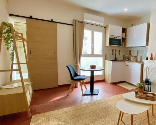 une chambre avec une table et une chaise ainsi qu'une cuisine dans l'établissement Studio en plein cœur du centre historique, à Aigues-Mortes