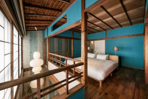 a bedroom with a bunk bed and blue walls at Matsunoma Machiya House in Kanazawa