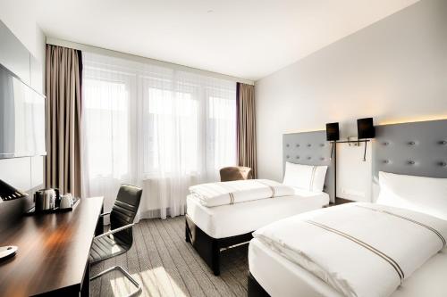 Premier Inn München City Ost في ميونخ: غرفة فندقية بسريرين ومكتب