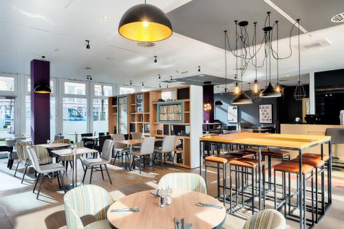 a restaurant with tables and chairs and a bar at Premier Inn München City Ost in Munich