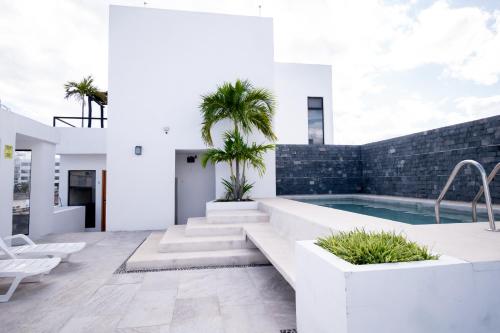 a courtyard with a pool and palm trees in a house at Arkana 9 Suites Grupo Amber - Collection O in Playa del Carmen