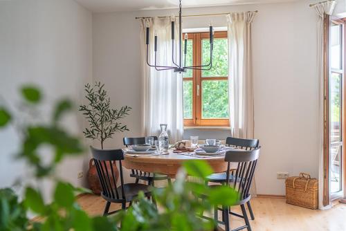 ein Esszimmer mit einem Tisch mit Stühlen und einem Kronleuchter in der Unterkunft Stilvolle Seewohnung in Utting in Utting am Ammersee