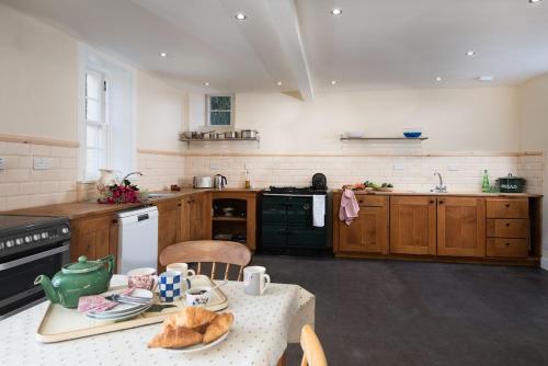 a kitchen with a table with a cat on the table at Mossfennan House in Drummelzier
