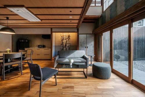 a living room with a couch and a table and chairs at Matsunoma Machiya House in Kanazawa