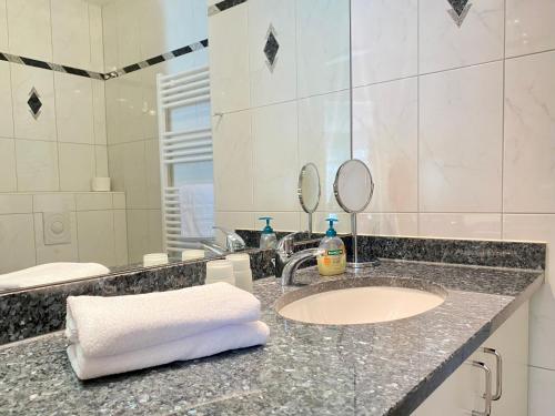 ein Bad mit einem Waschbecken und einem Spiegel in der Unterkunft Residenz Bleichröder - Ferienwohnung 12 in Heringsdorf