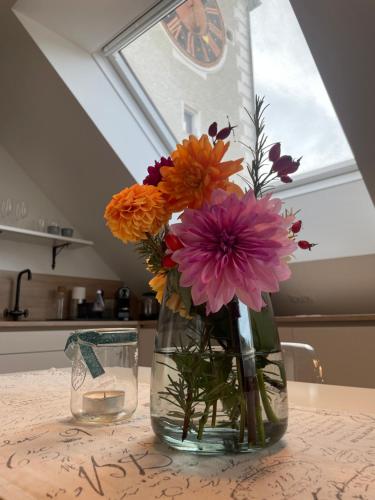 un jarrón lleno de flores sentado en una mesa en Kerschbaumer.Apartments, en Waidhofen an der Ybbs