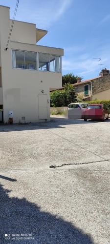 un bâtiment blanc avec une porte dans un parking dans l'établissement T2 -Six Fours - 300m plage, à Six-Fours-les-Plages