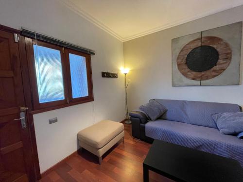 a living room with a blue couch and a stool at Apartamento Puerto Rosario centro in Puerto del Rosario