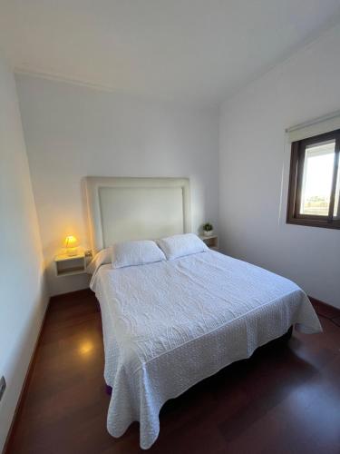 a bedroom with a bed with a white bedspread and a window at Apartamento Puerto Rosario centro in Puerto del Rosario