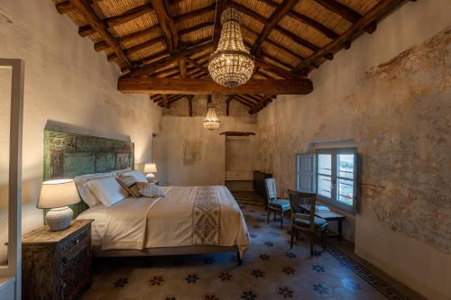 a bedroom with a bed and a chandelier at Palazzo Boyl 1840 in Cagliari