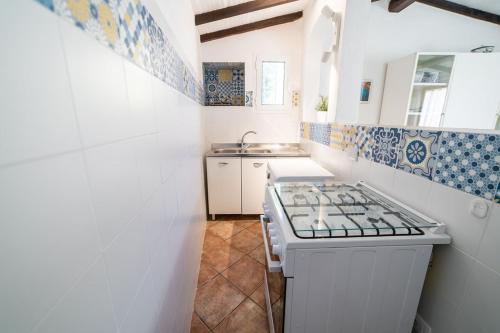 a small kitchen with a stove and a sink at La Cicocca in Portoferraio